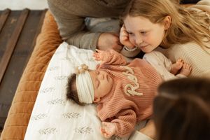 A series of intimate moments between a parent and baby on a couch showing tender embraces and affectionate interaction.