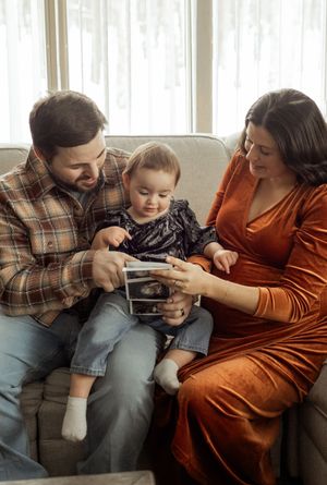 A family sits together on a couch looking at a smartphone screen in a sequence of four connected photos.