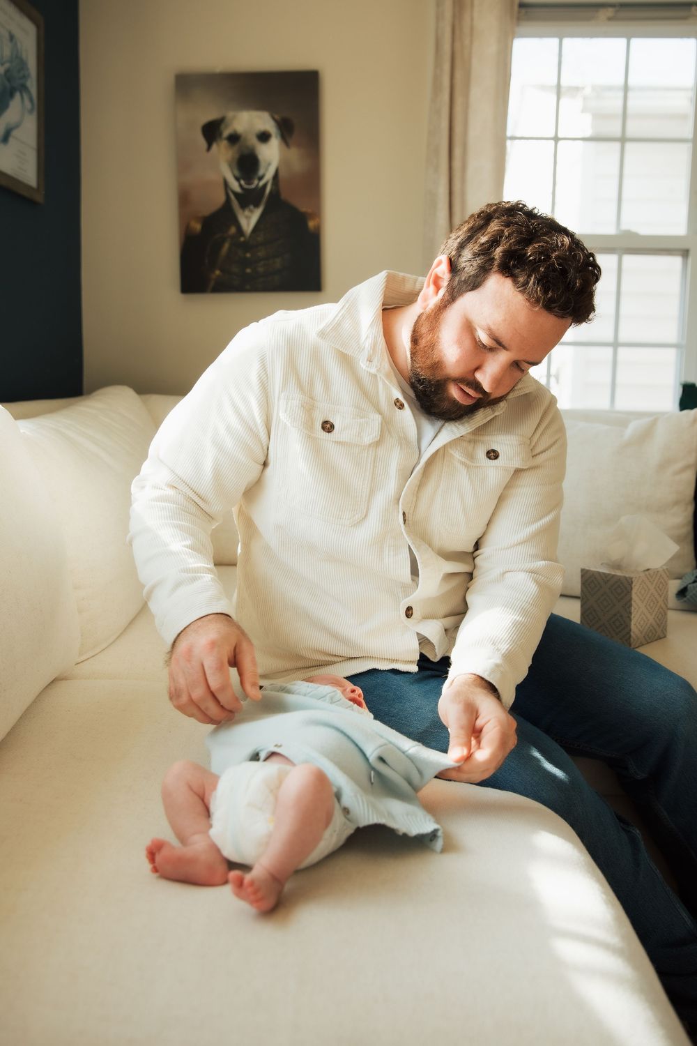 Bearded father in white jacket interacting with baby on white sofa, Bristol Rhode Island Portsmouth