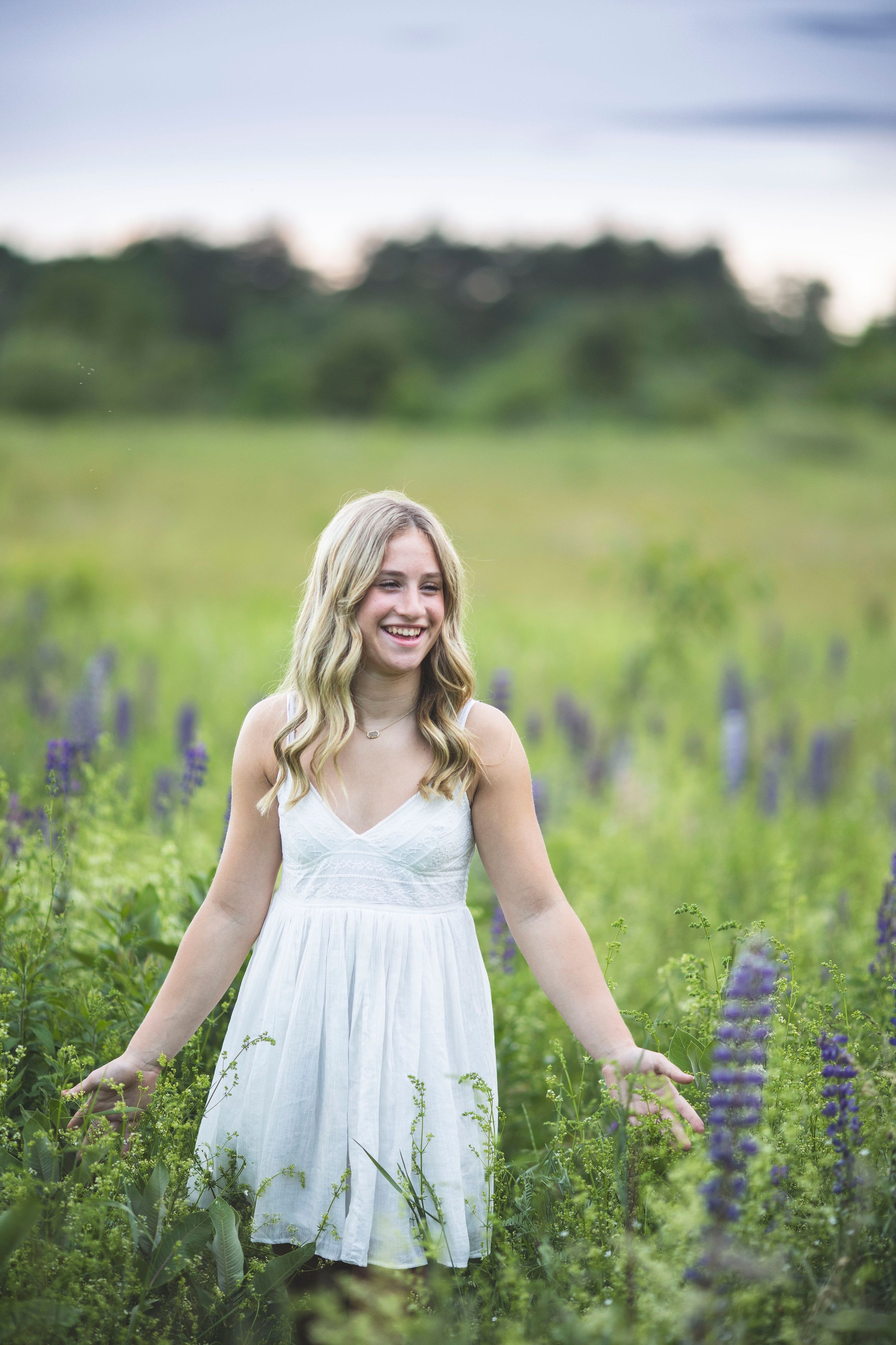 A teenager standing in a field of flowers