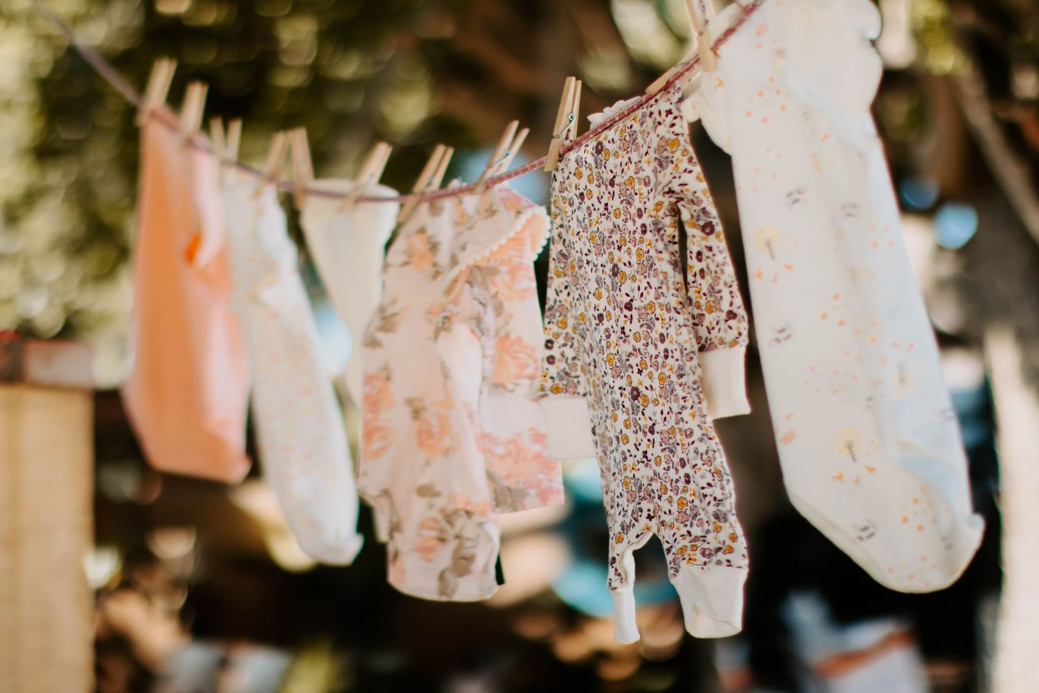 Delicate paper decorations with glitter details hanging on string in warm lighting.