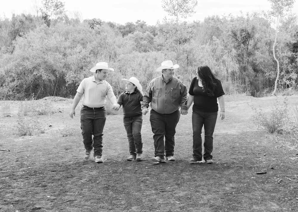 family walking on path looking at each other, cowboy hats, love, black and white