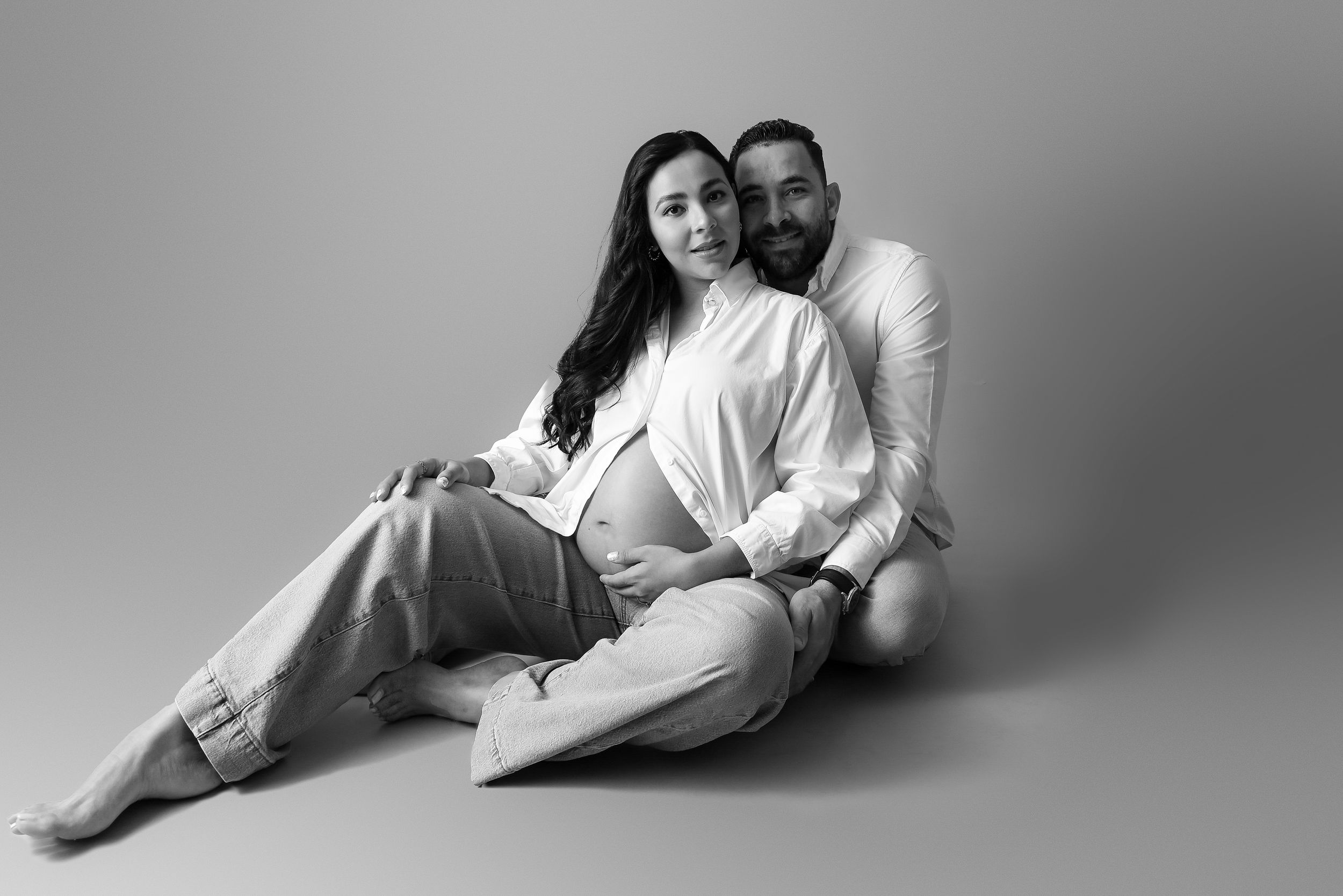 pregnant woman with her partner in a relaxed mood and pose, timeless black and white image, aesthetic, simple and cute