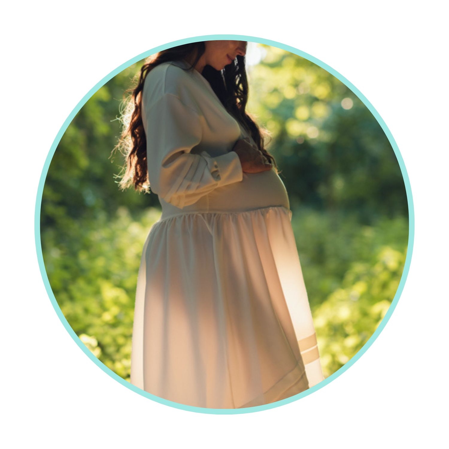 Artistic maternity photo showing pregnant belly in white flowing dress.