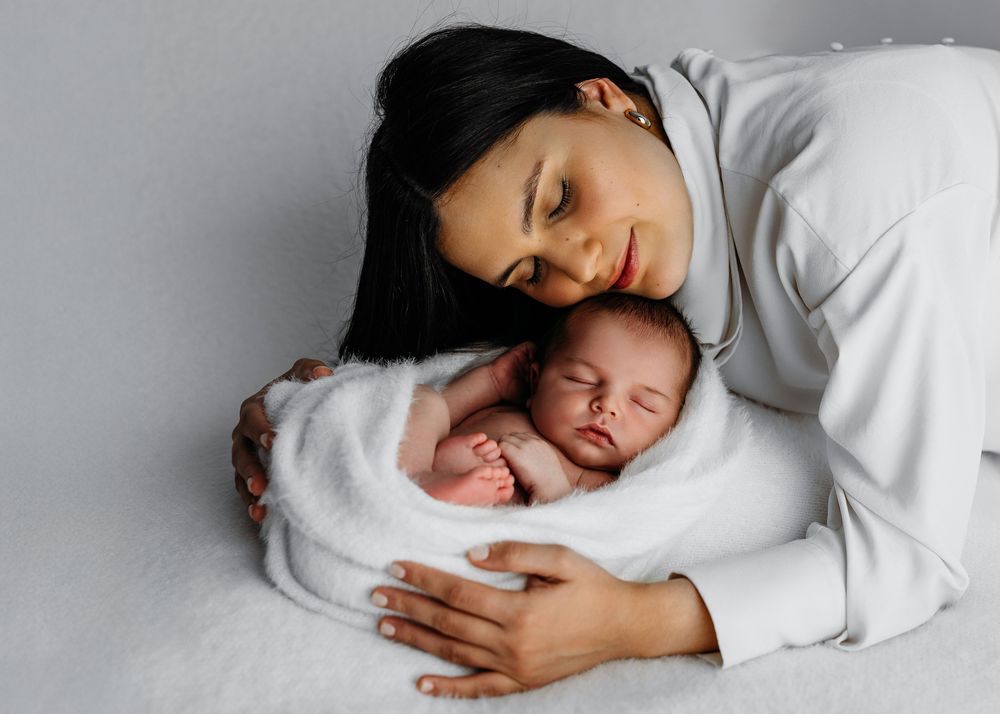 Simple minimalist photo of infant resting against white background in gentle natural light.