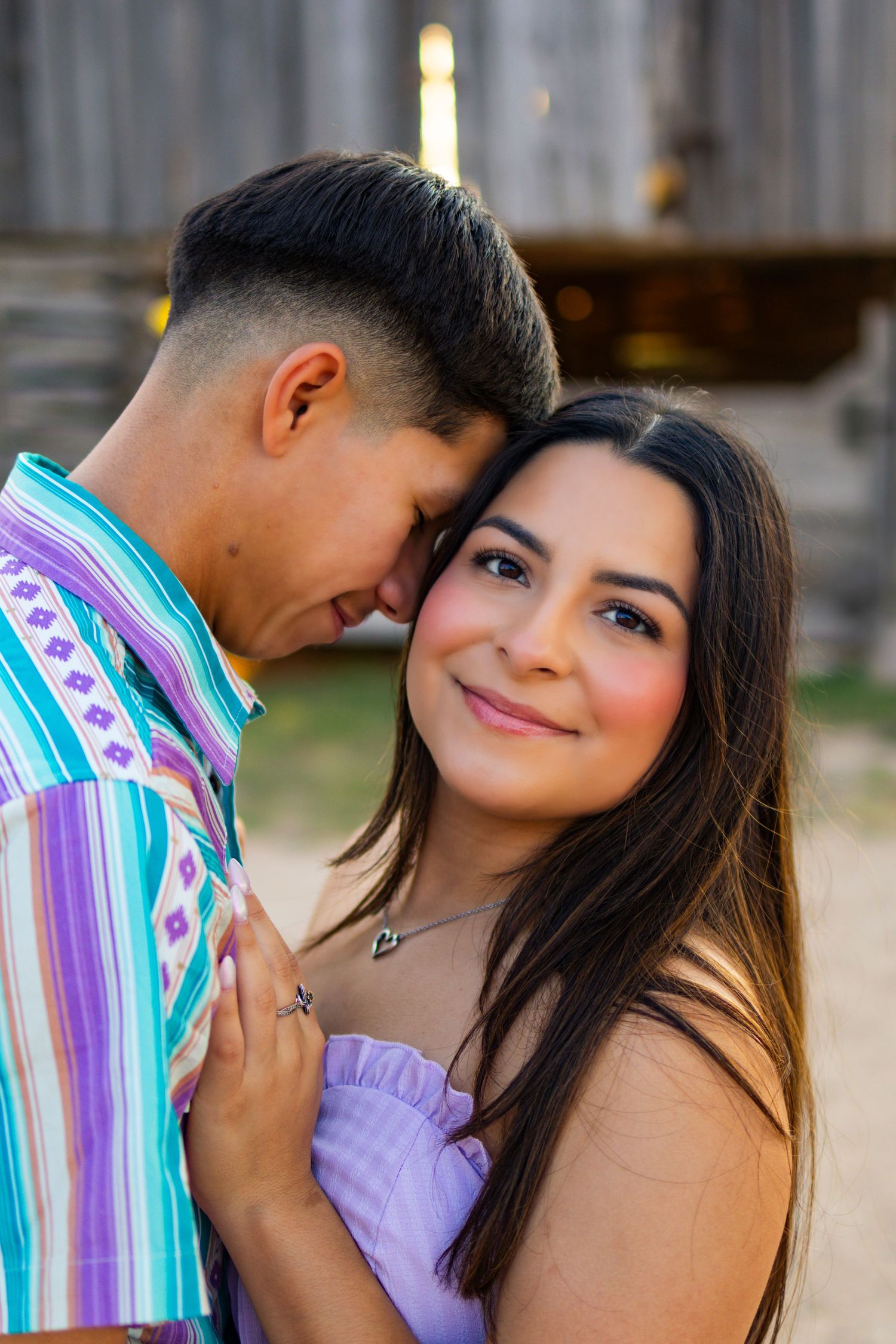 A tender moment between a couple against an industrial background during golden hour.