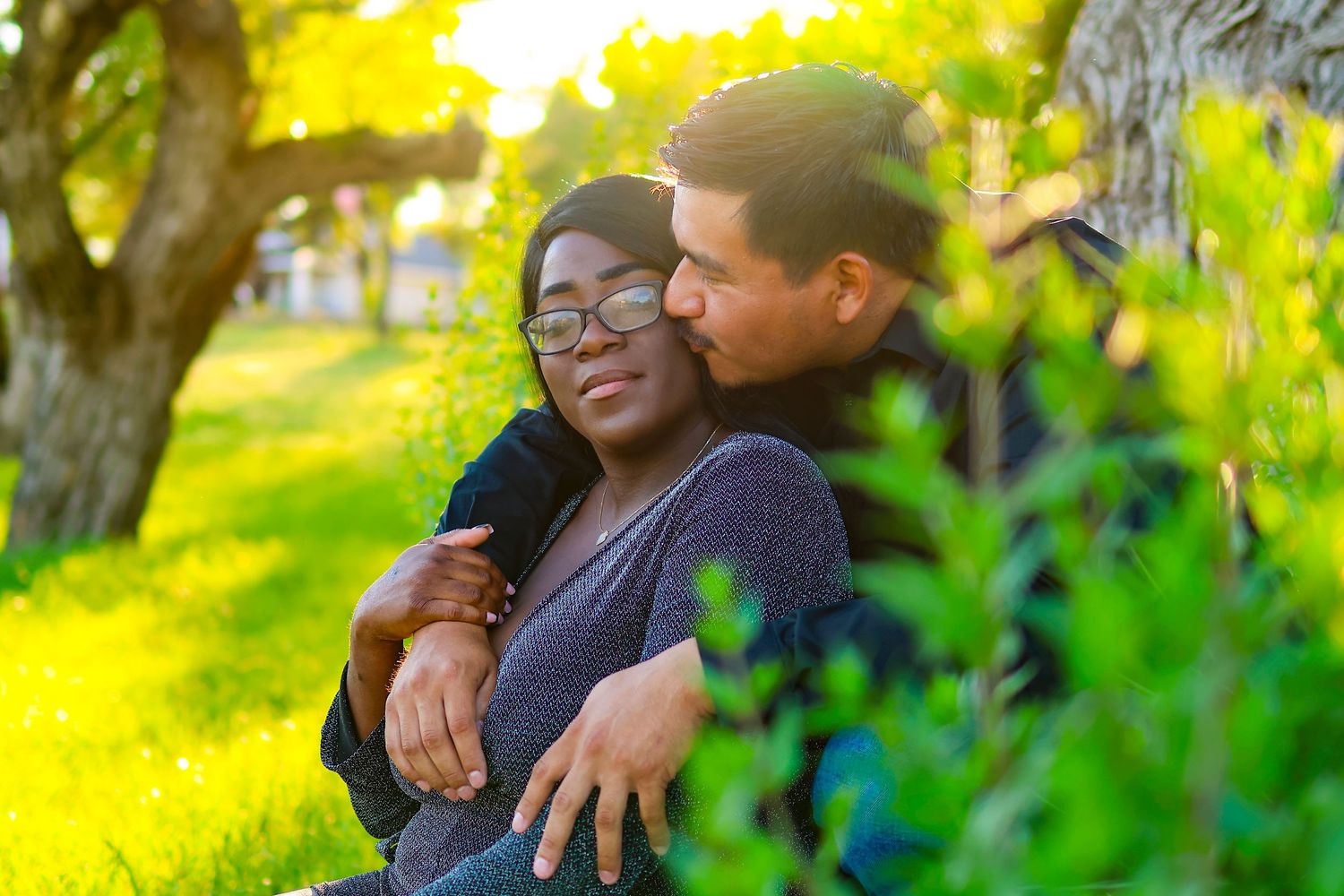 Sweet tender moment between a couple enjoying each other's company in a sunny park.