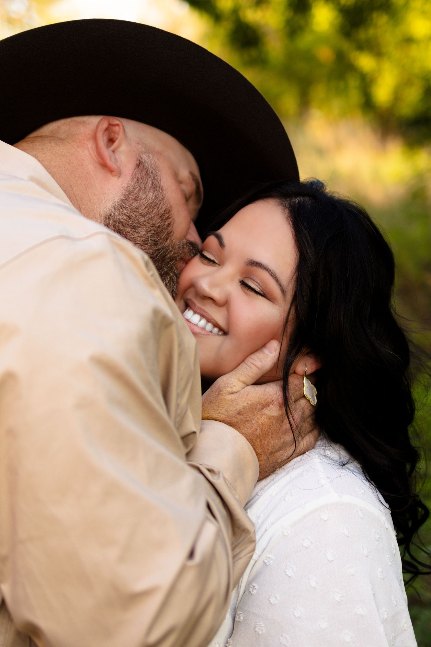 An intimate portrait of a couple sharing a tender moment against a warm autumn background.