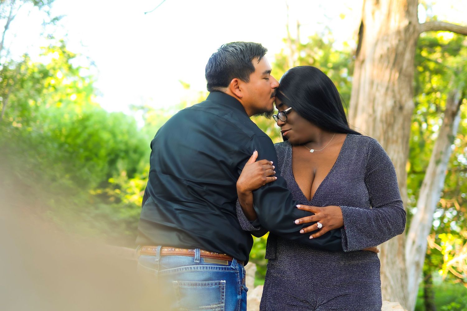 Intimate outdoor portrait of a couple embracing and showing affection in a natural setting.