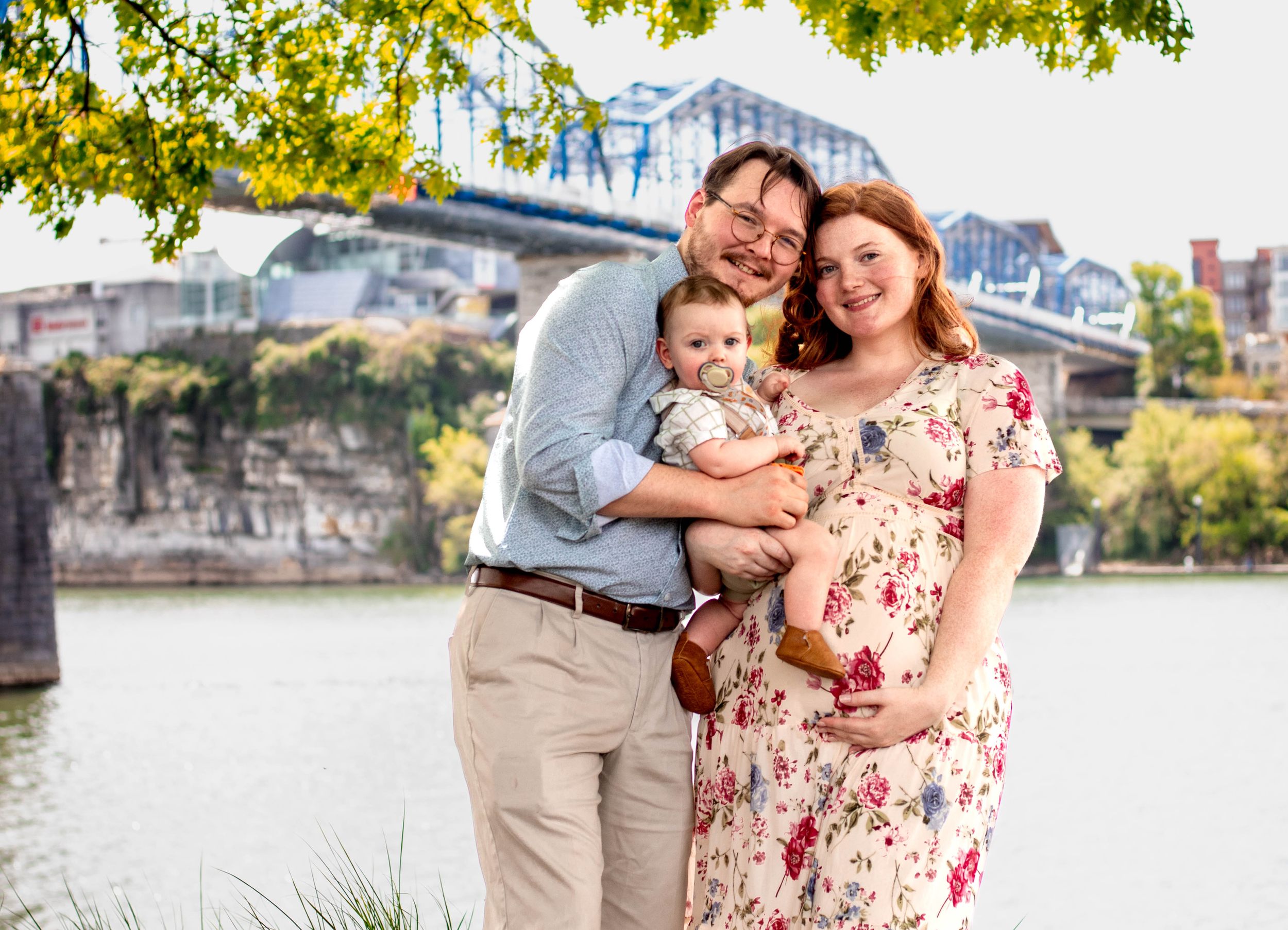 Family of three with their baby smiling during a lifestyle photo session with tay portraits the best Chattanooga family photographer