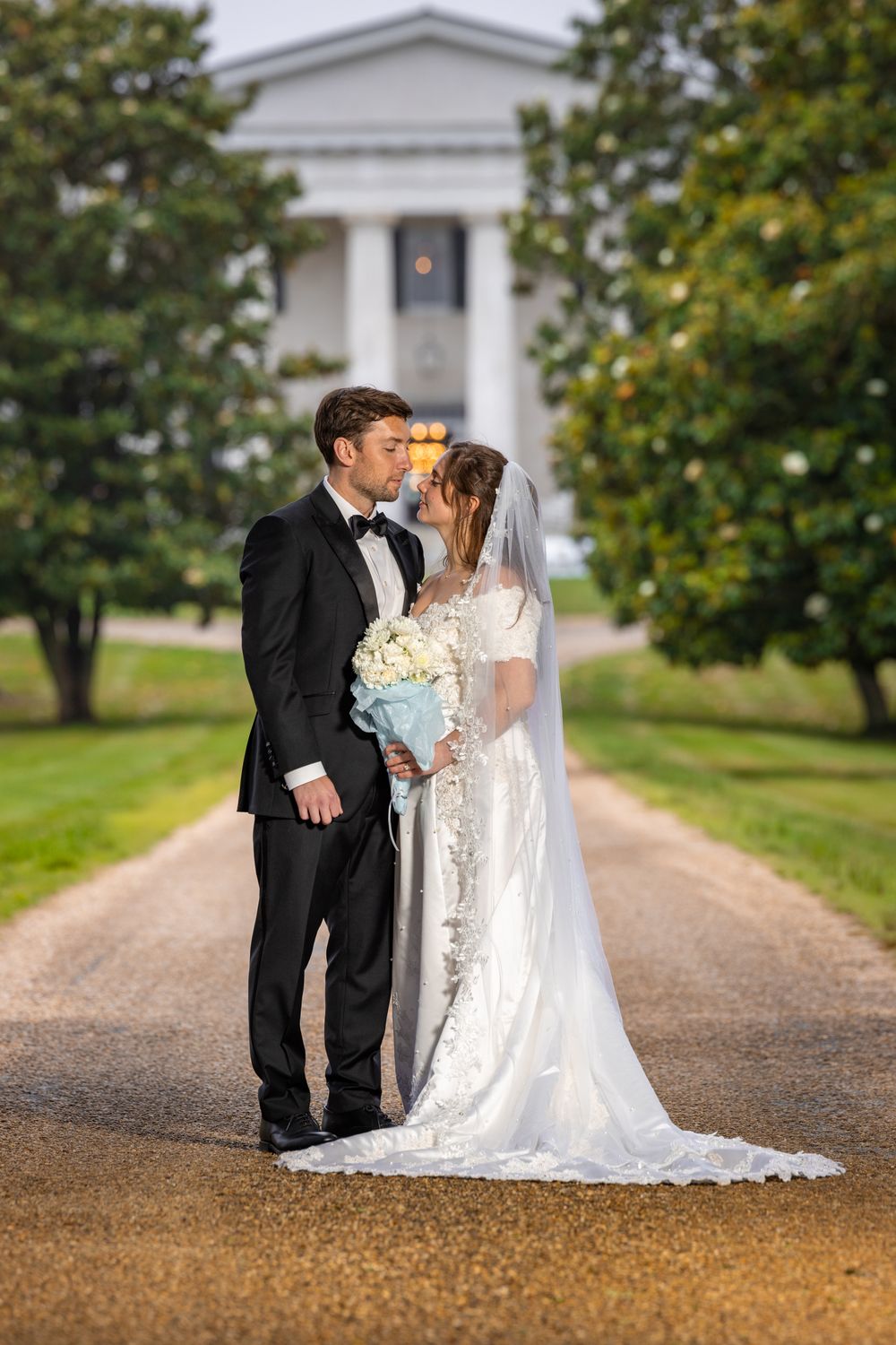 Outdoor wedding ceremony with bride and groom exchanging vows beneath a large tree