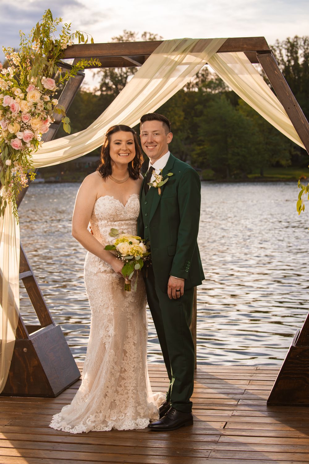 A couple just married posing for their portrait near the lake.