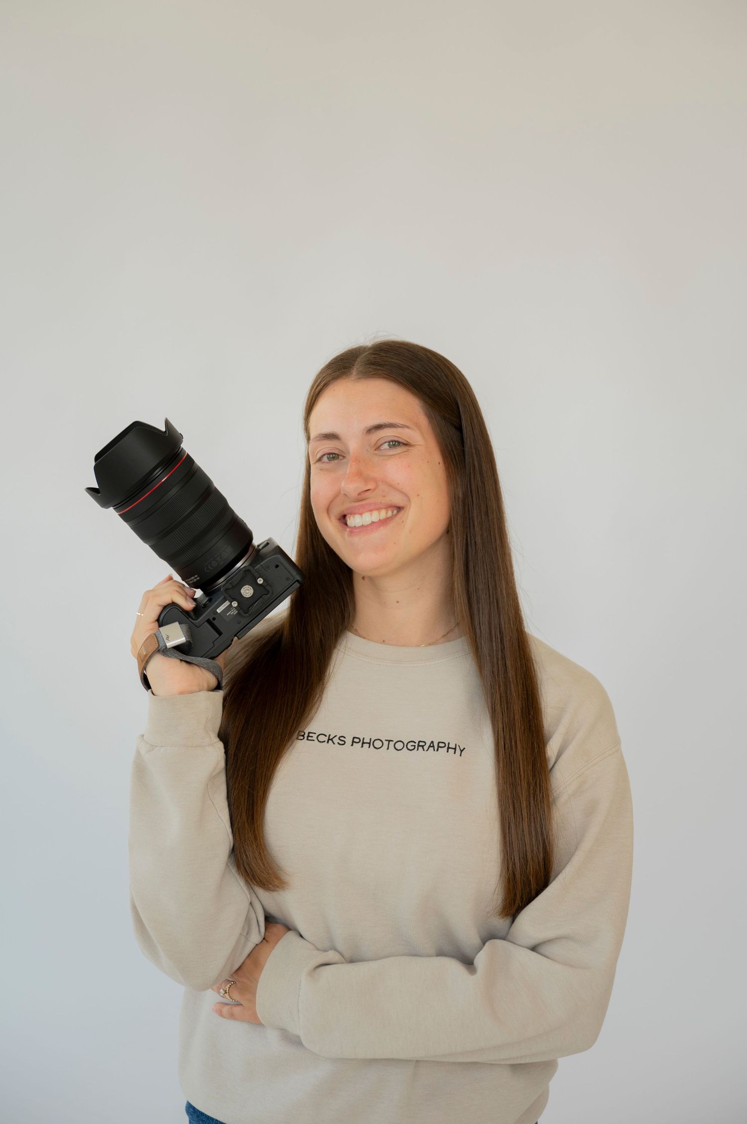 family, newborn and maternity photographer standing with her camera in a studio in Oakland County michigan
