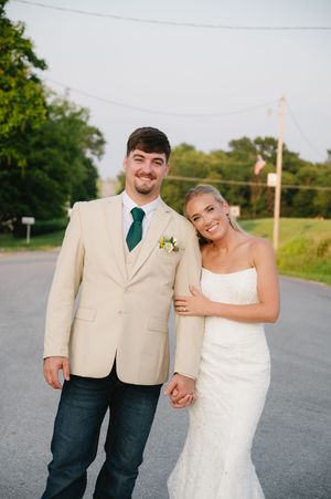 Bride and groom wedding portrait, bride holds grooms arm.
