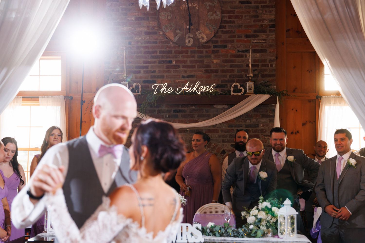 Bride and groom share their first dance at The Aikens wedding reception in a rustic venue.