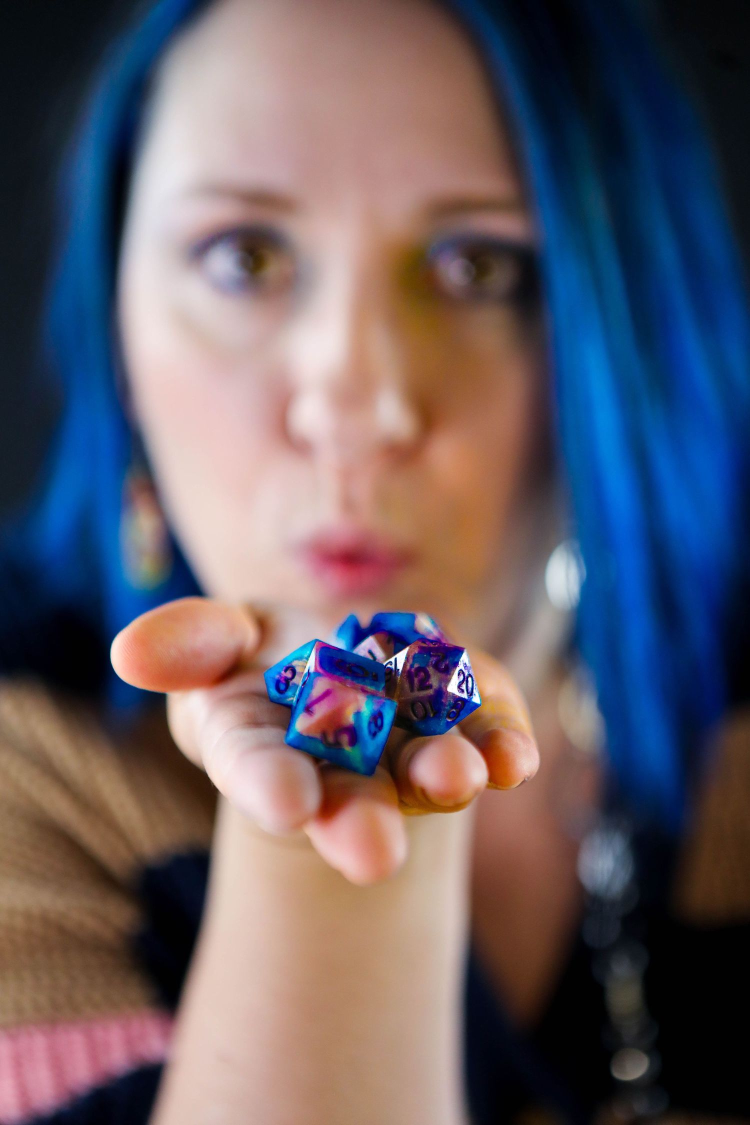 Close-up photo showcasing colorful blue and purple gaming dice held in palm.