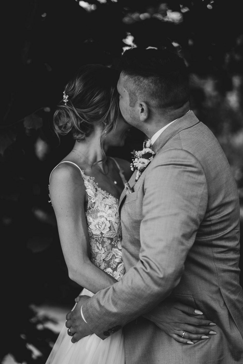 Black and white intimate moment of newlyweds embracing.