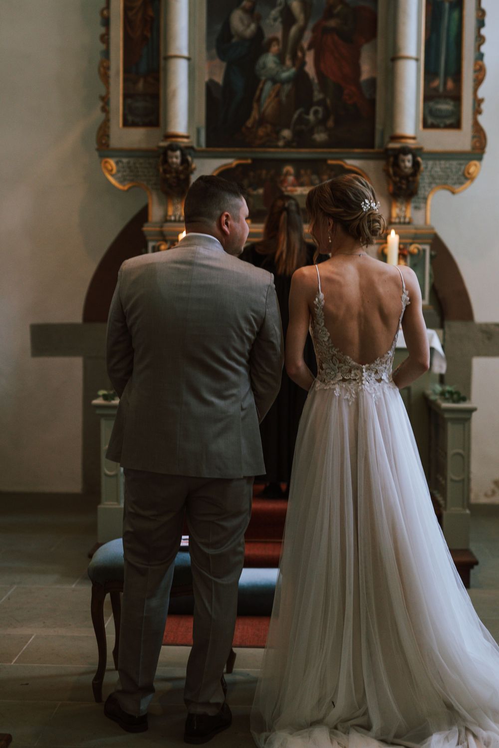 A wedding ceremony in a historic church with ornate decorations and paintings.