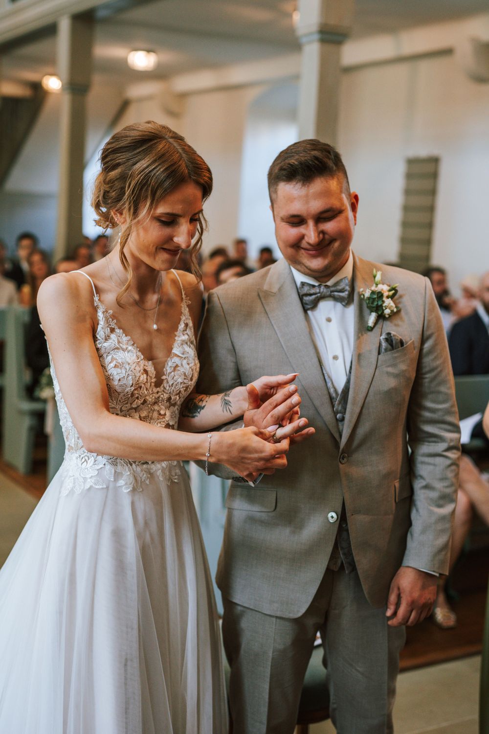 Newlyweds share a joyful moment during ring exchange at their church wedding ceremony.