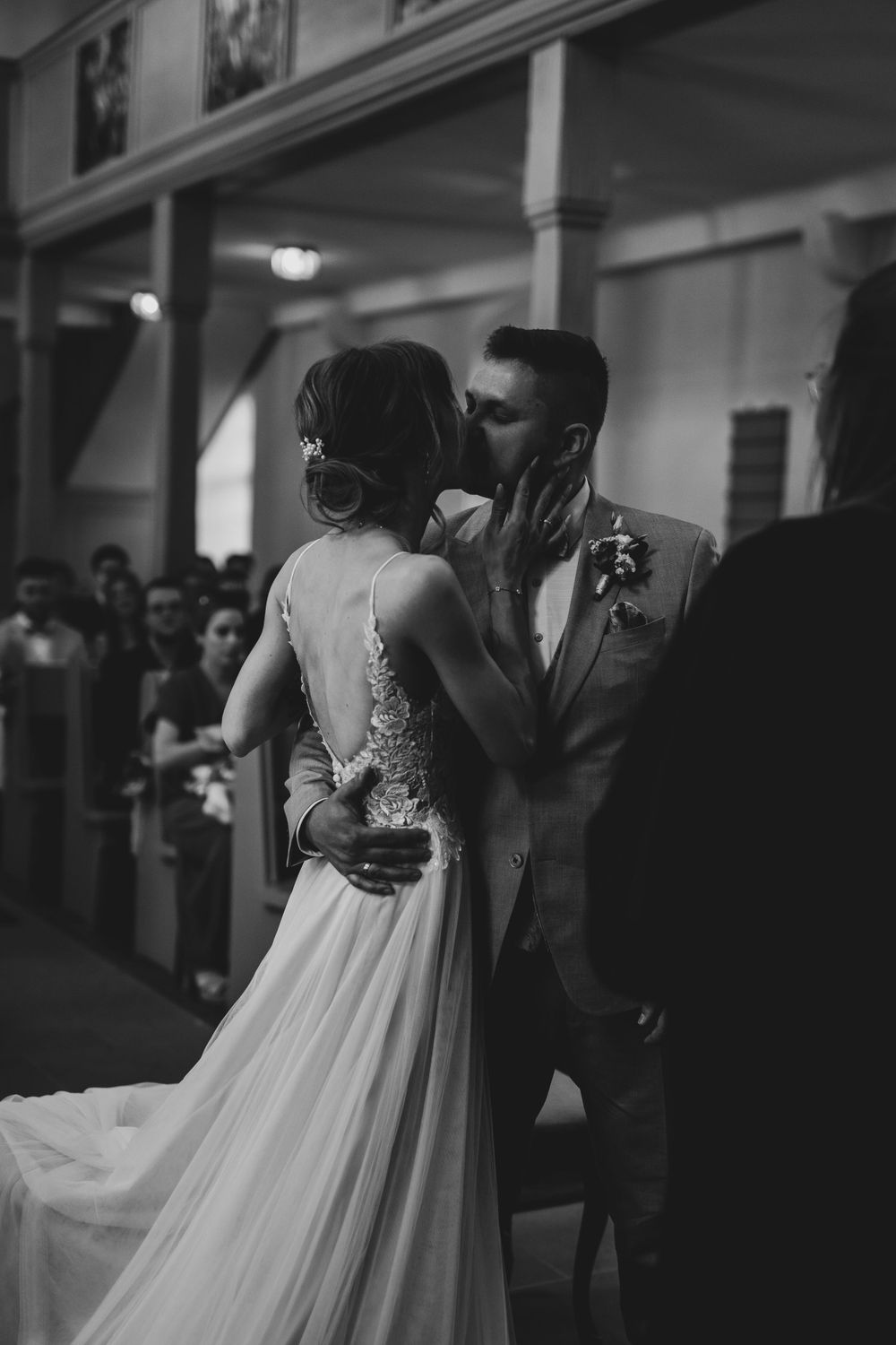 Intimate first kiss moment during traditional church wedding ceremony.
