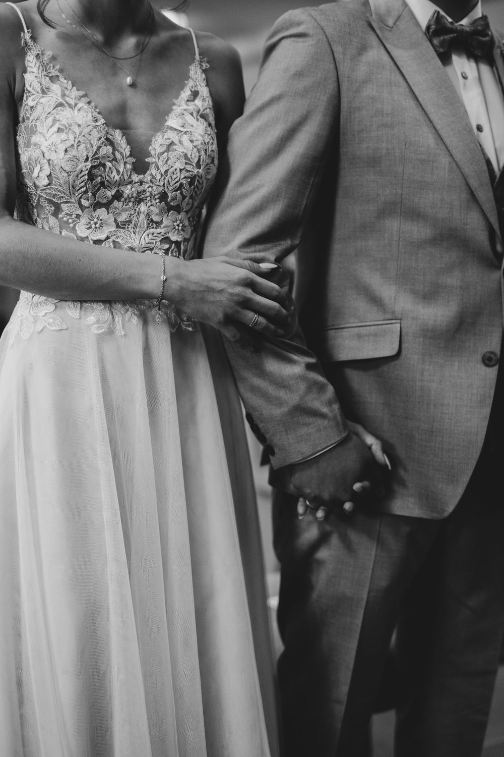 Close-up of elegant wedding attire showing lace details and formal wear.