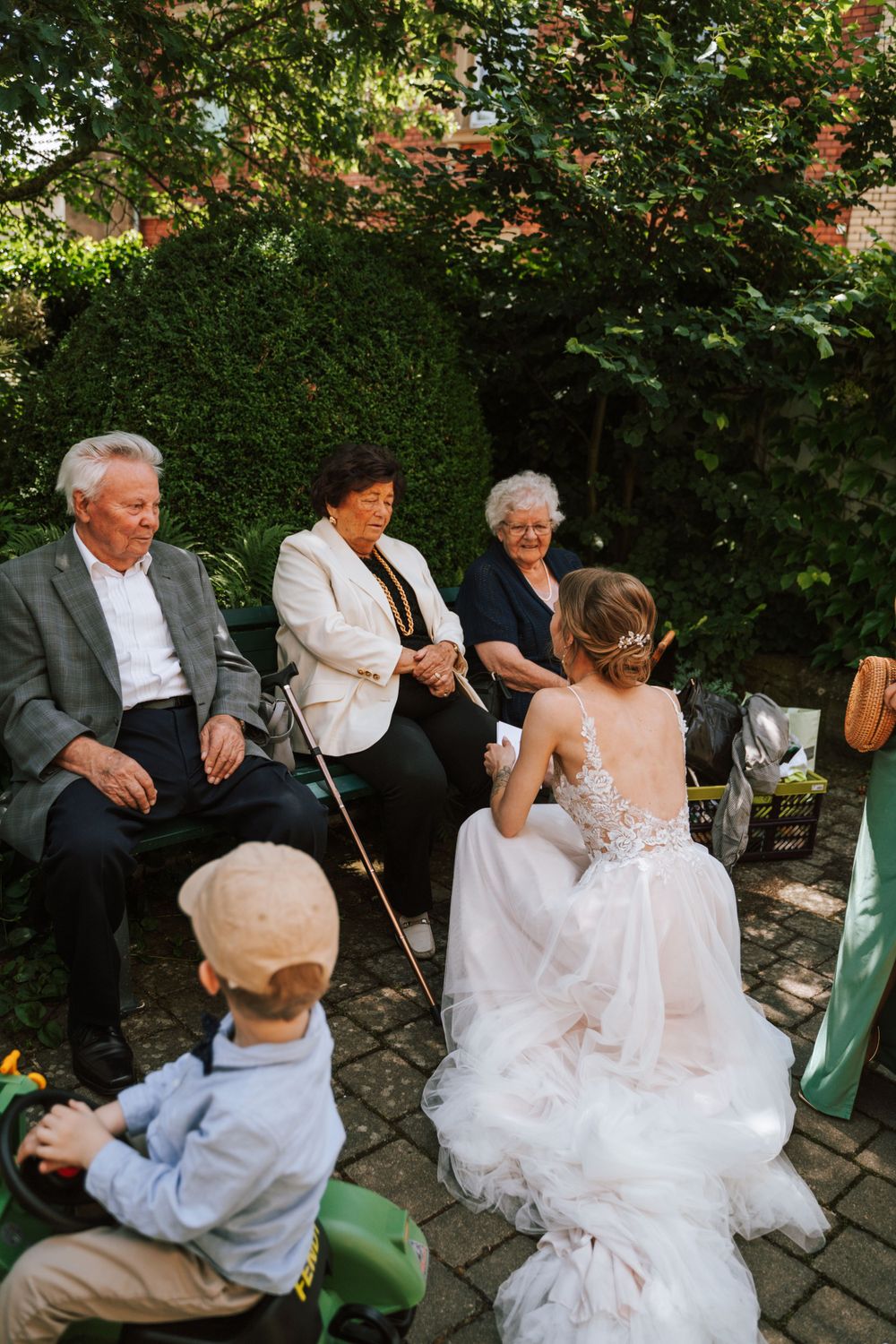 Wedding guests gather in a garden setting for an outdoor celebration.