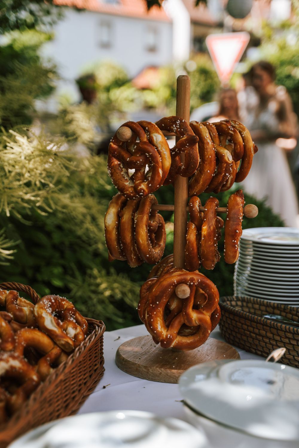 Fresh baked pretzels displayed in baskets at an outdoor wedding reception.