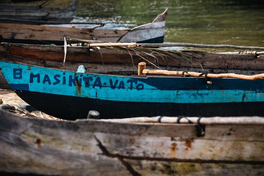 Weathered blue and wooden boats moored together on calm water.