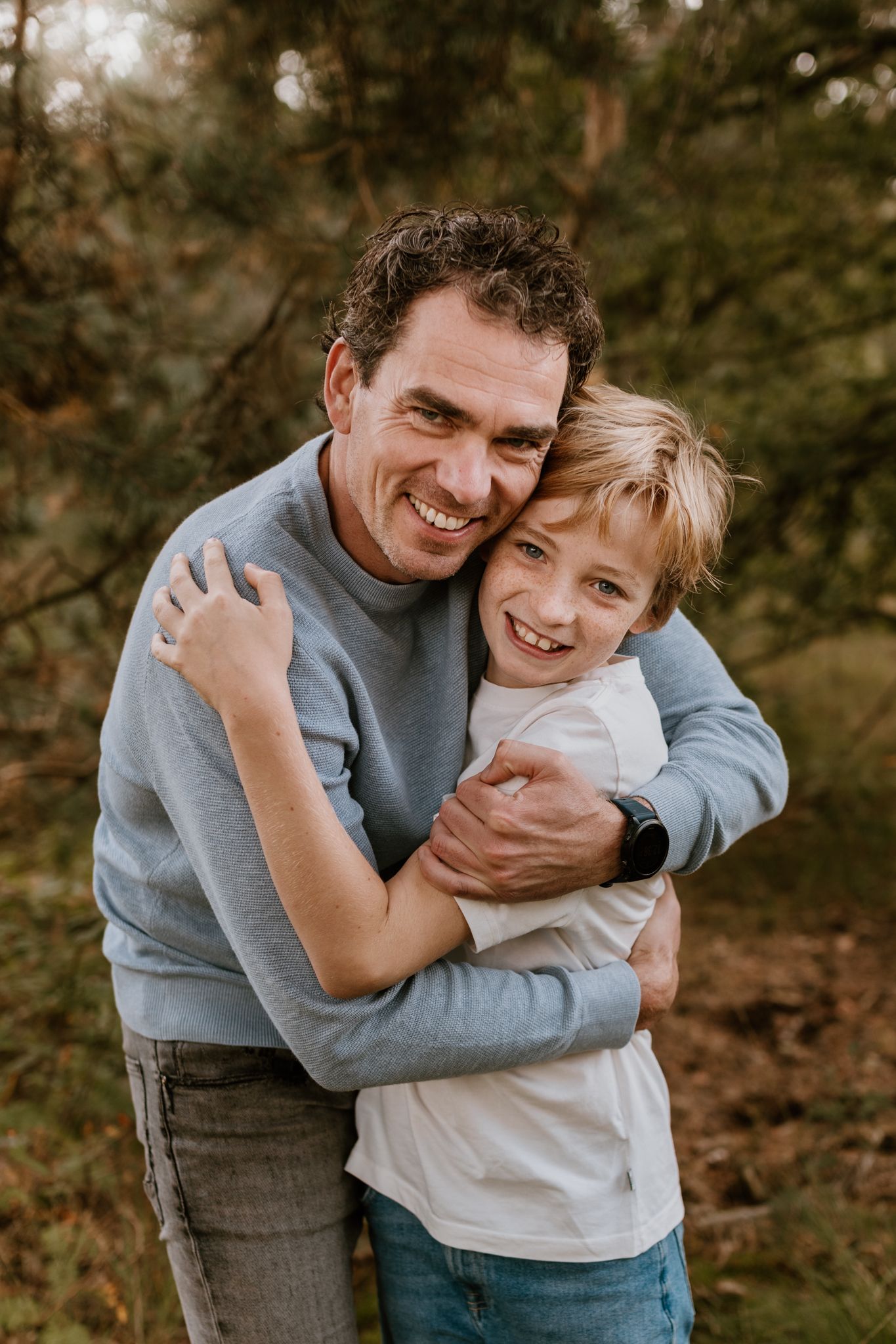 Vader en zoon fotoshoot, houden elkaar vast,