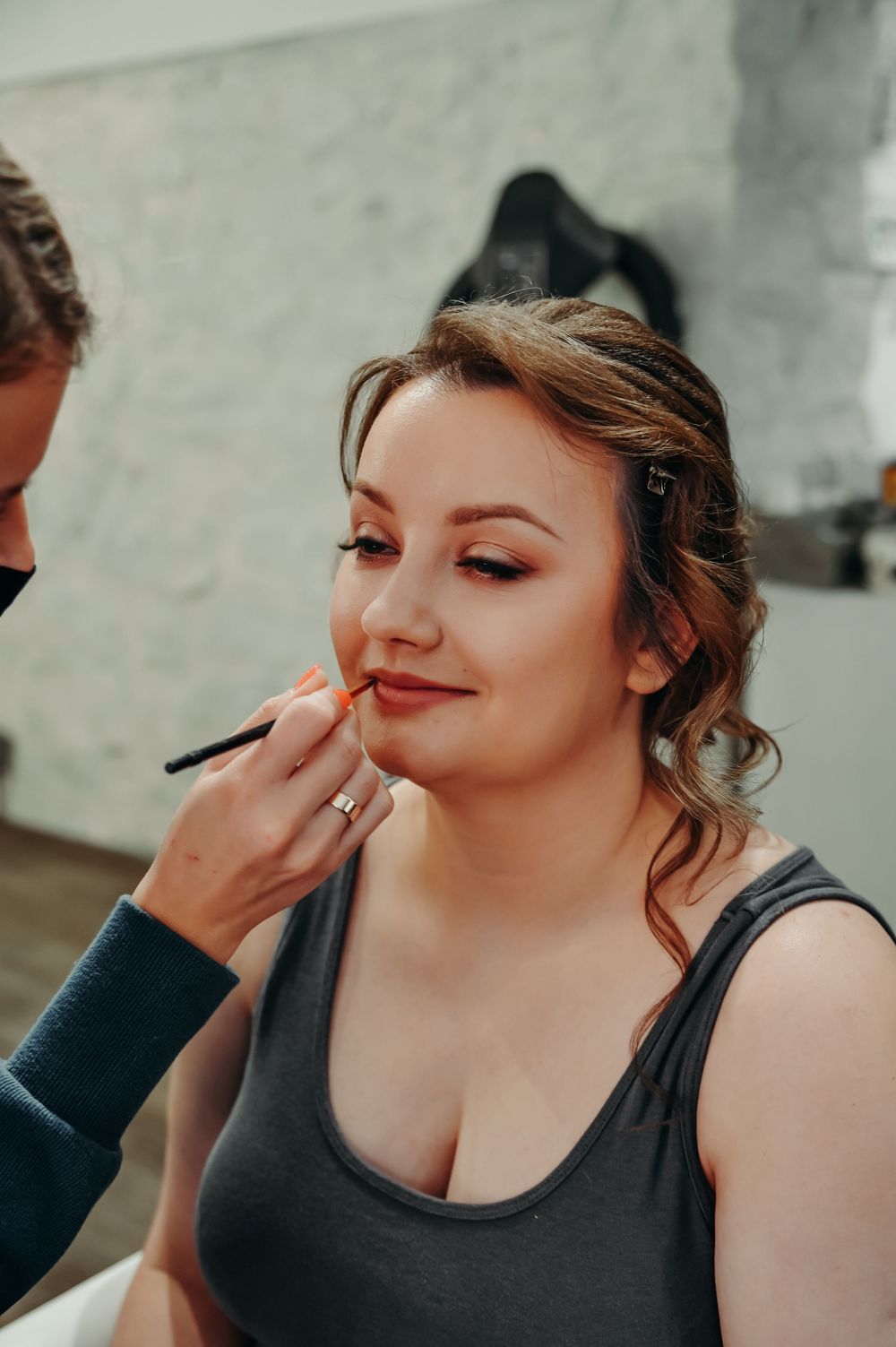 Makeup artist applying cosmetics during a professional beauty session.