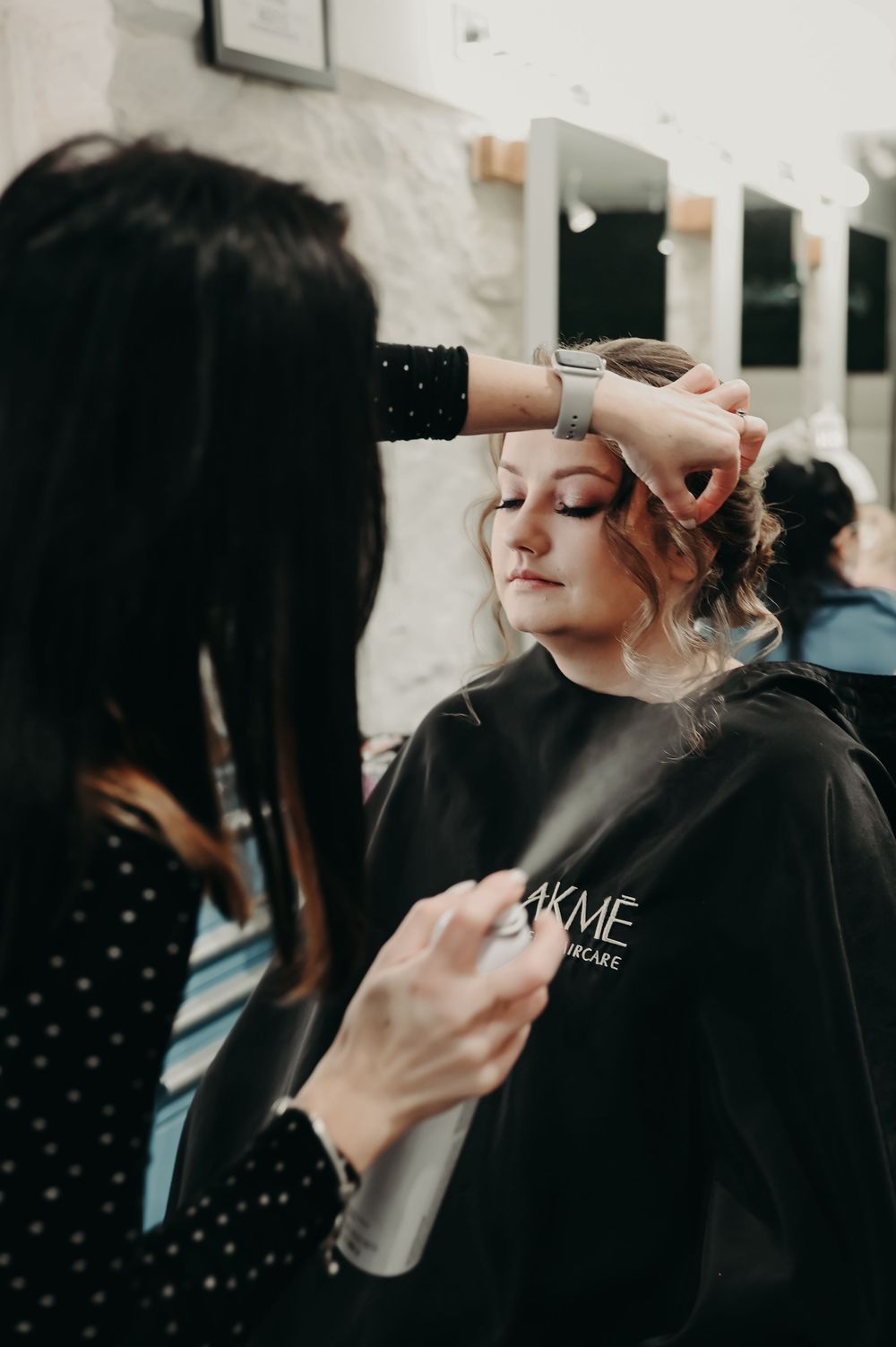 Beauty professional working on client's styling in modern salon environment.