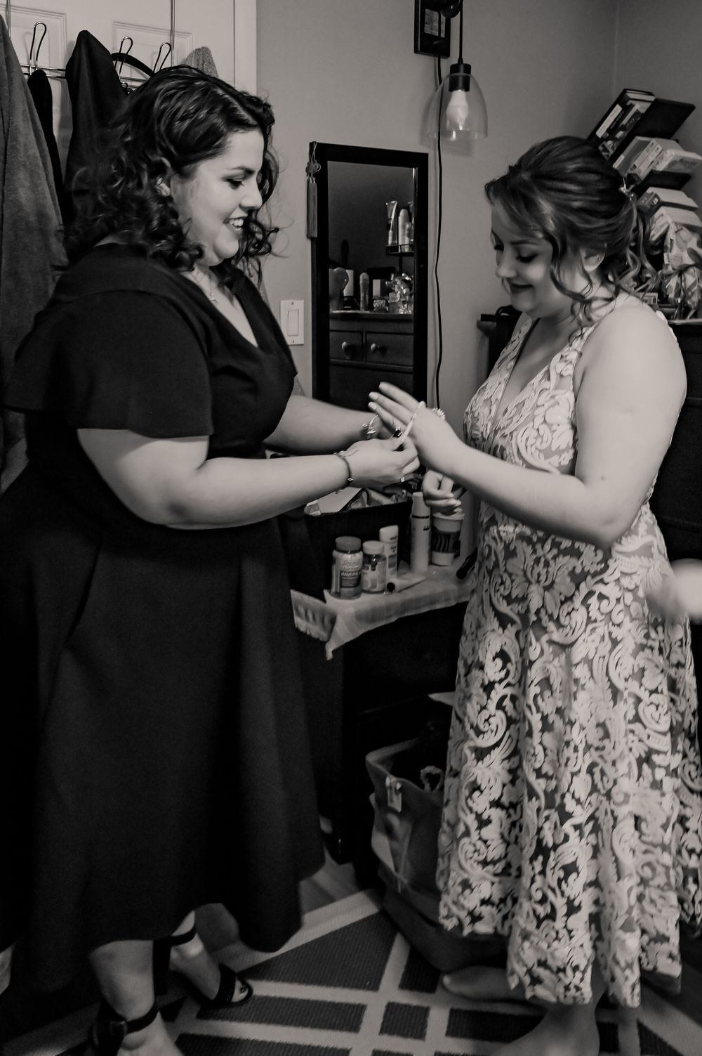 A black and white capture of two people examining jewelry together.