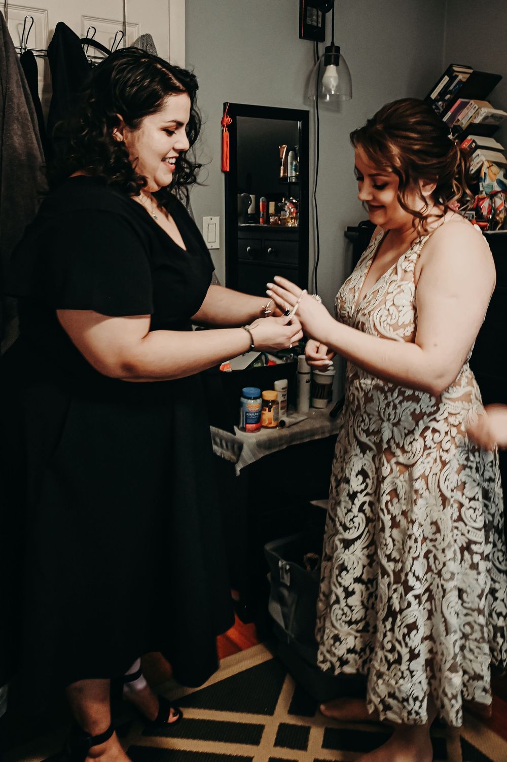 Two people sharing a joyful moment while looking at jewelry in a dressing room.