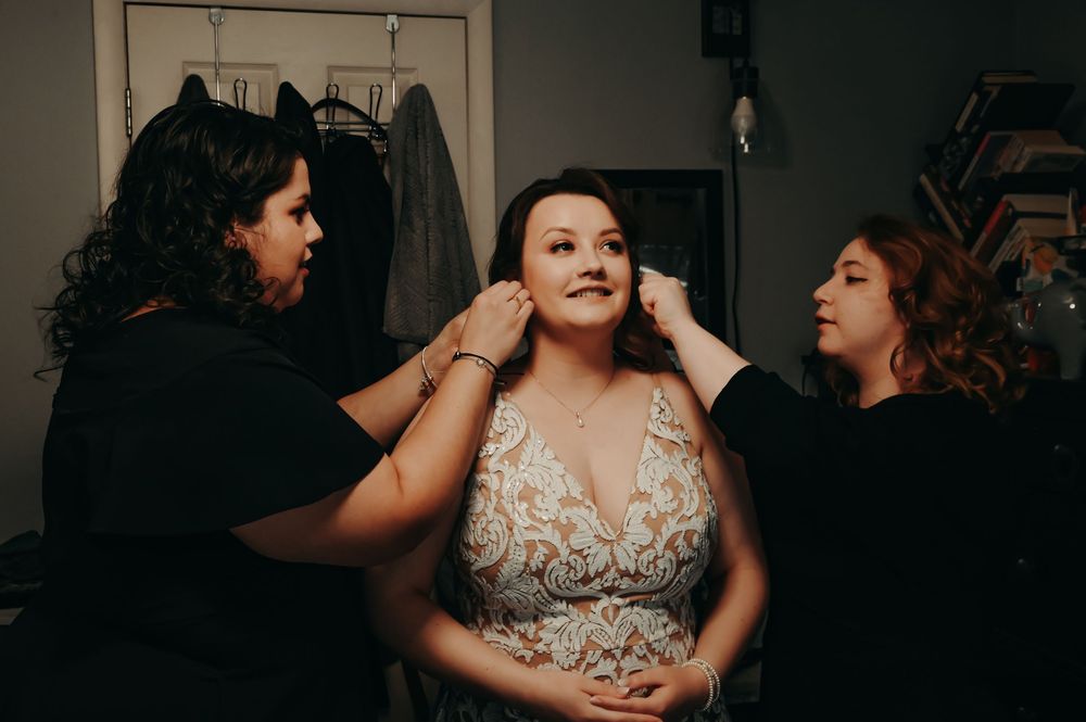 Final touches being applied during wedding preparations in a dressing room.