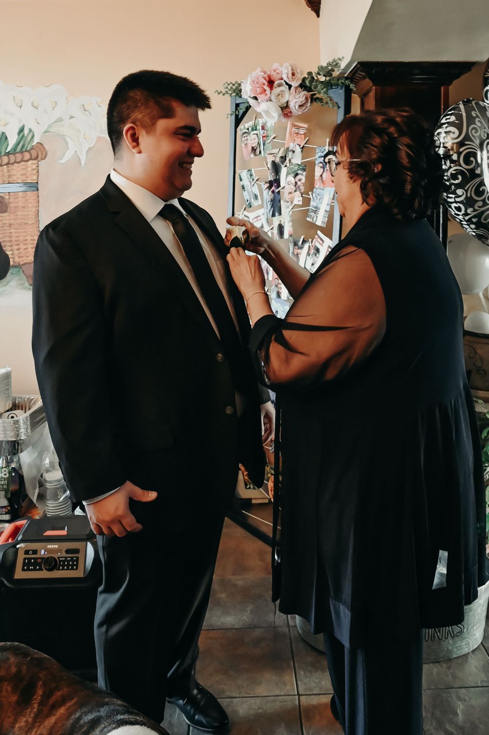Two people in formal black attire share a close moment at an indoor event.