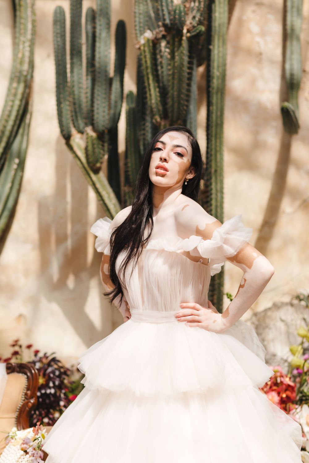 Elegant bridal portrait featuring white ballgown against desert setting with cactus plants.