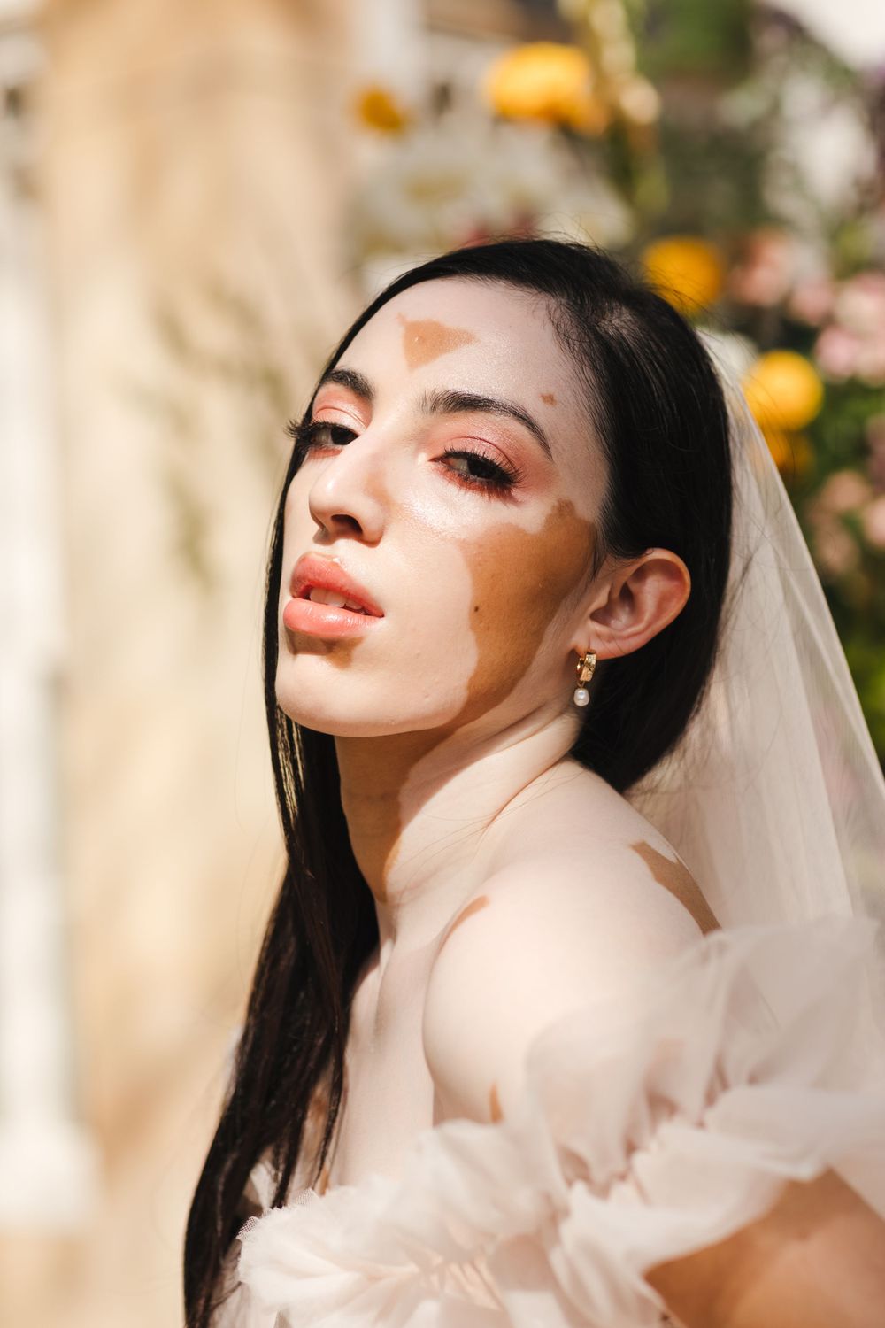 Artistic bridal portrait with dramatic lighting and delicate veil.