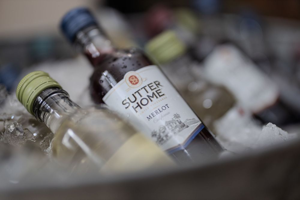 Bottles of Sutter Home wine chilling in ice at an event.