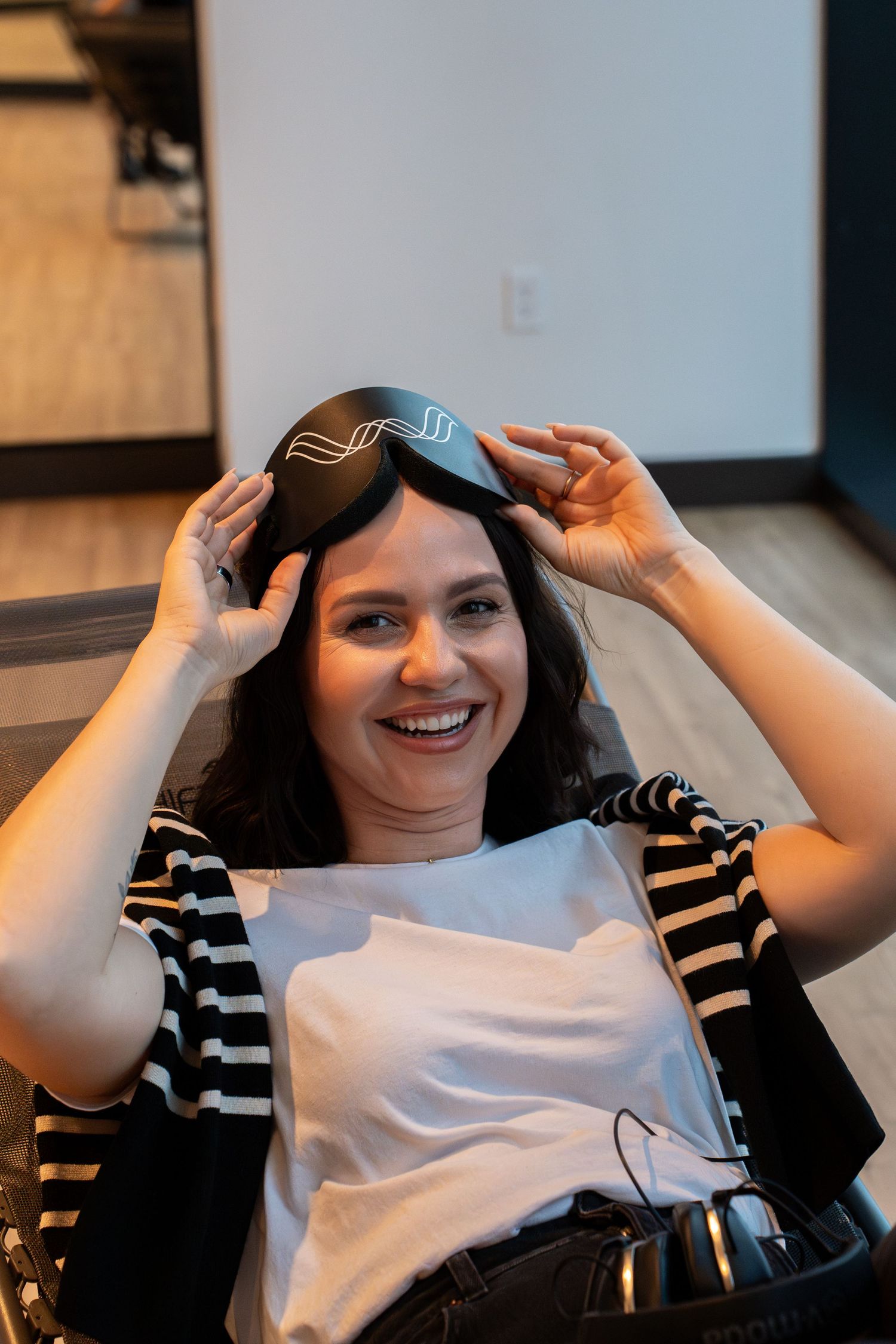 Someone lifting VR goggles while relaxing in a comfortable chair.