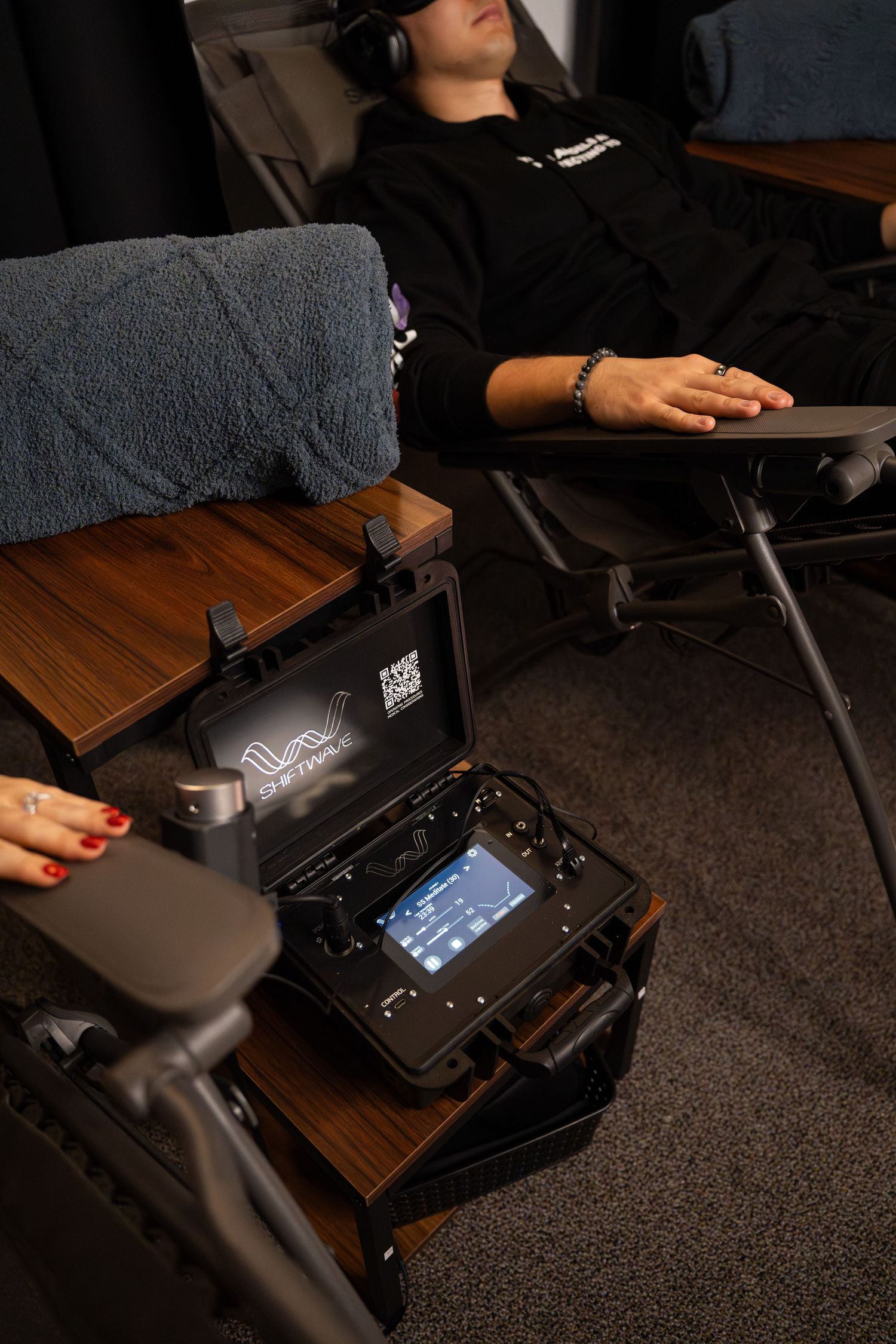 VR setup with black control unit display visible next to reclining chair.