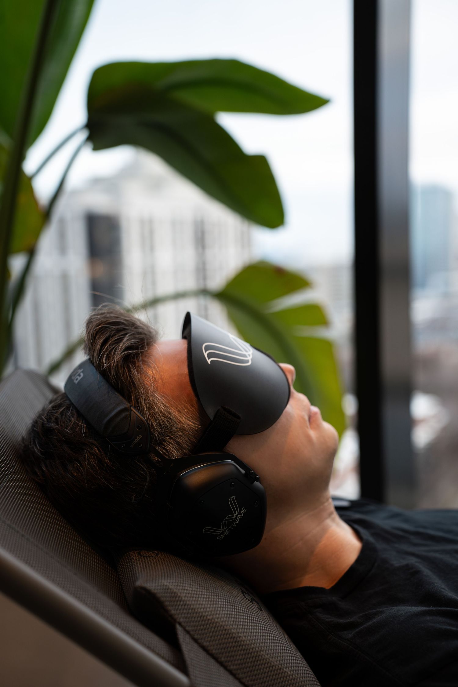 A relaxing scene with someone wearing a VR headset against large tropical plants.