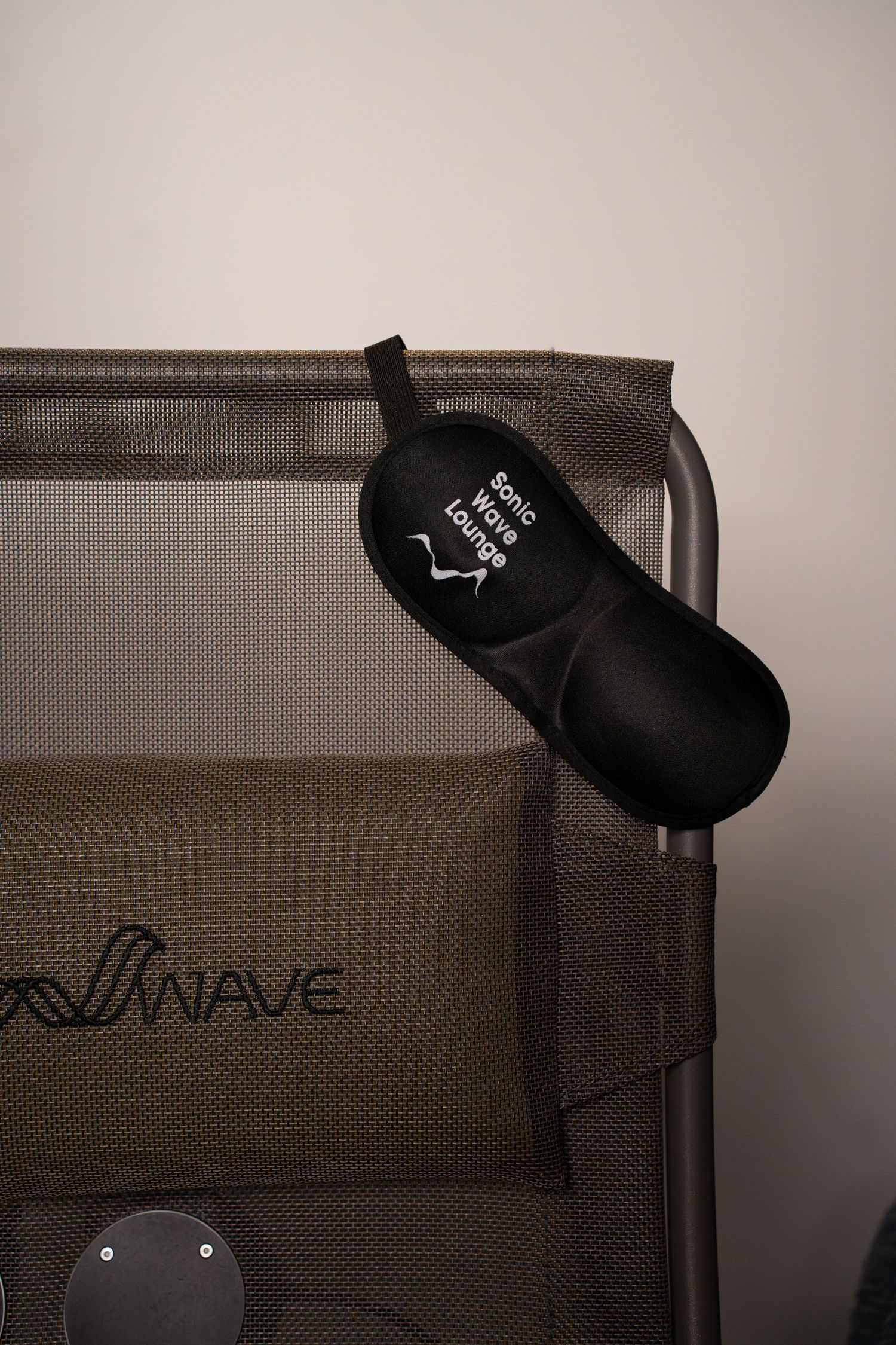 Black accessory pouch attached to a gray mesh chair with Wave branding.