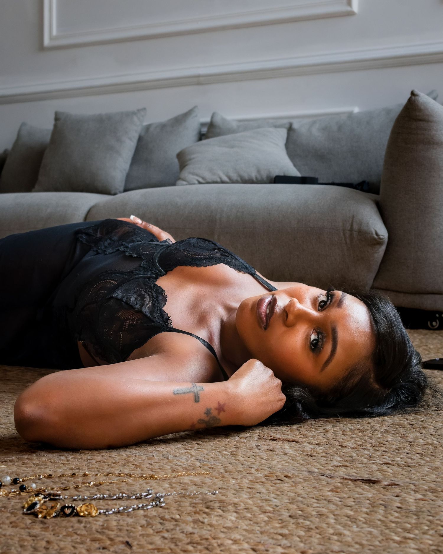 Dramatic indoor boudoir photo on carpet with couch in background.