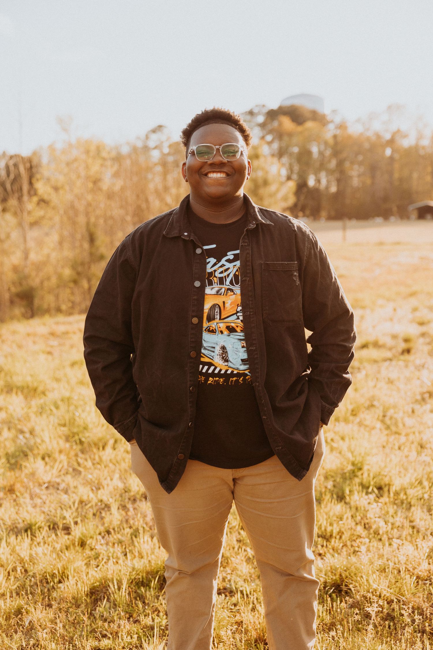 Boy standing in a field in Wilmington, NC smiling at the camera