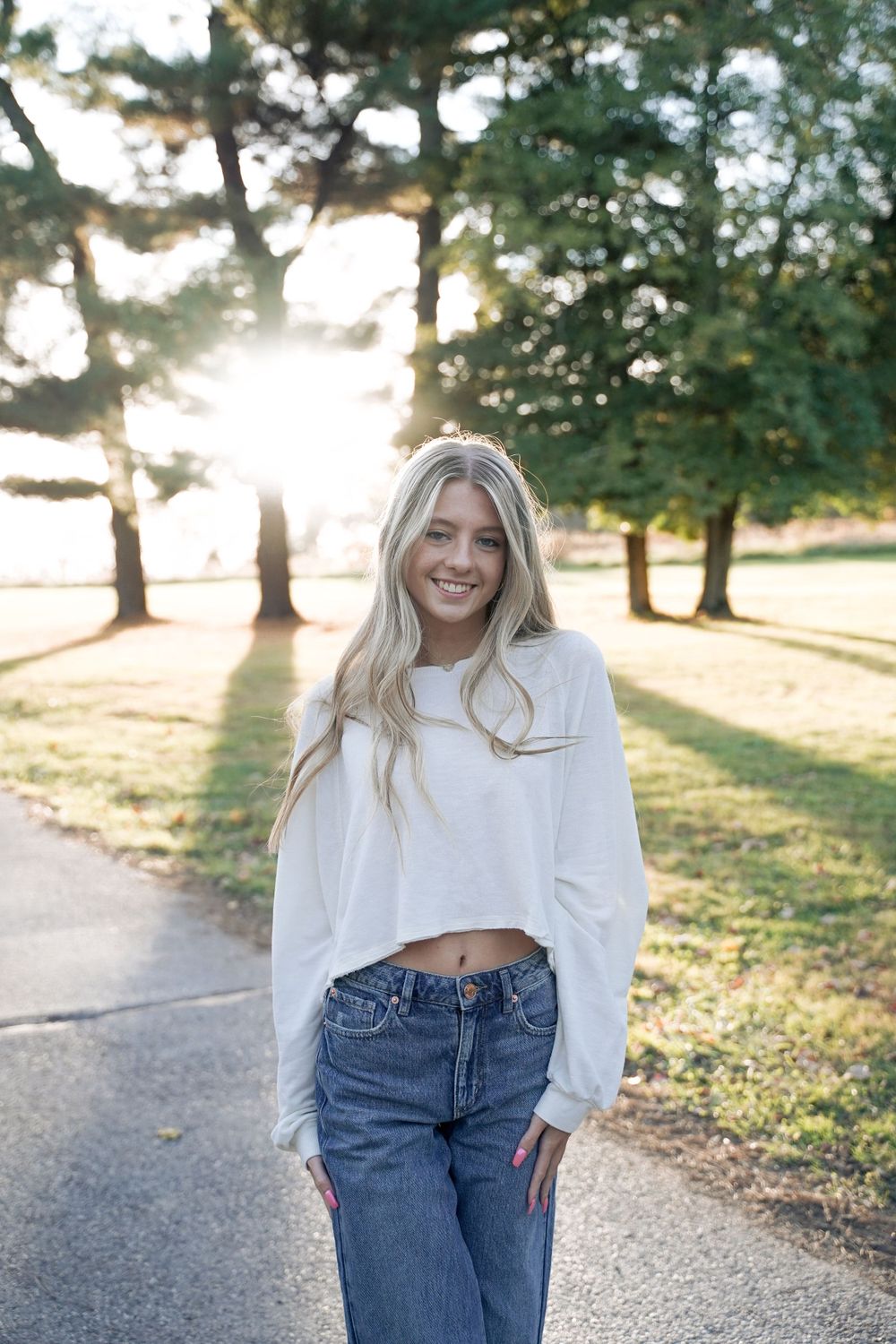 Casual outfit with cropped sweater and jeans captured during golden hour.