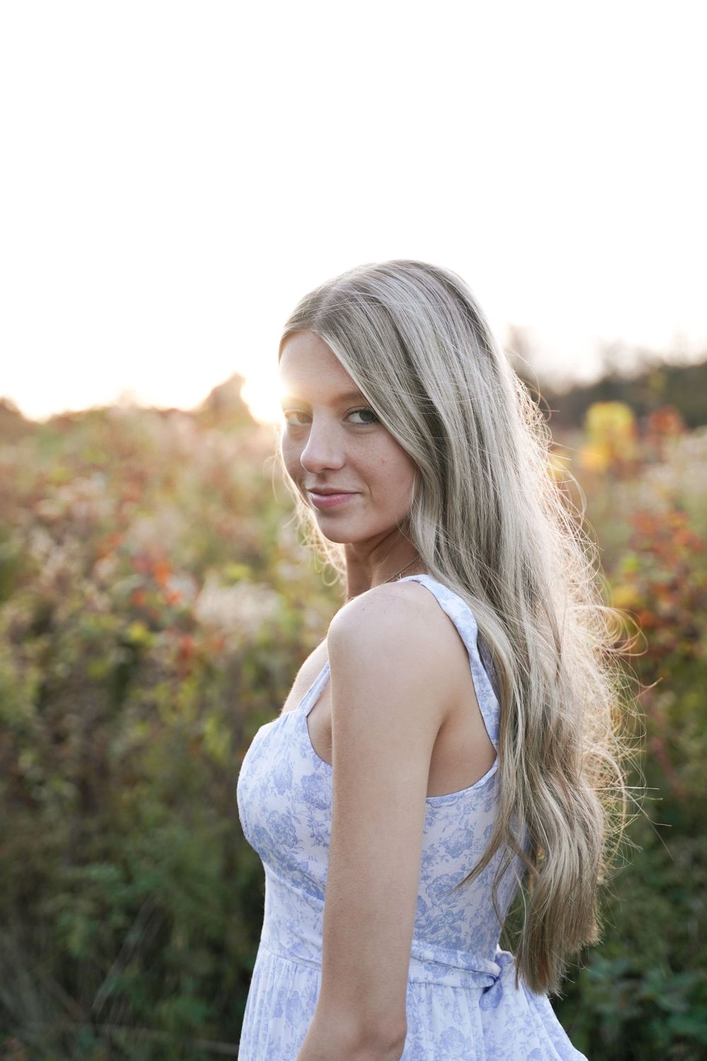 Delicate light blue floral dress photographed during sunset with bokeh background.