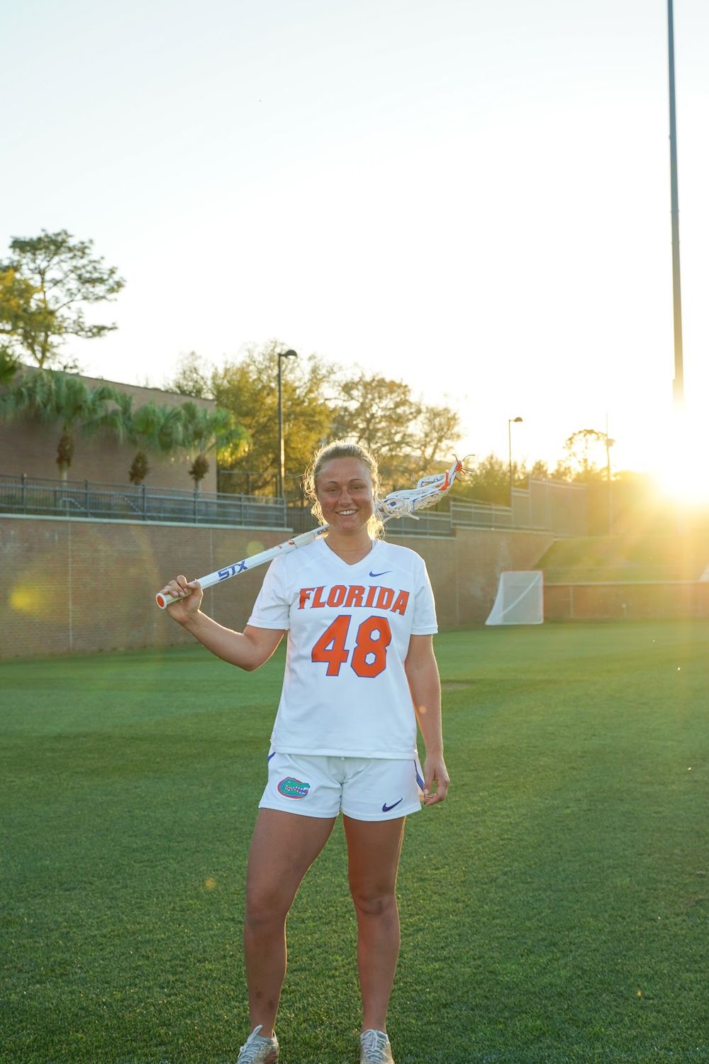 Athletic player wearing Florida jersey number 48 poses on sports field at sunset.