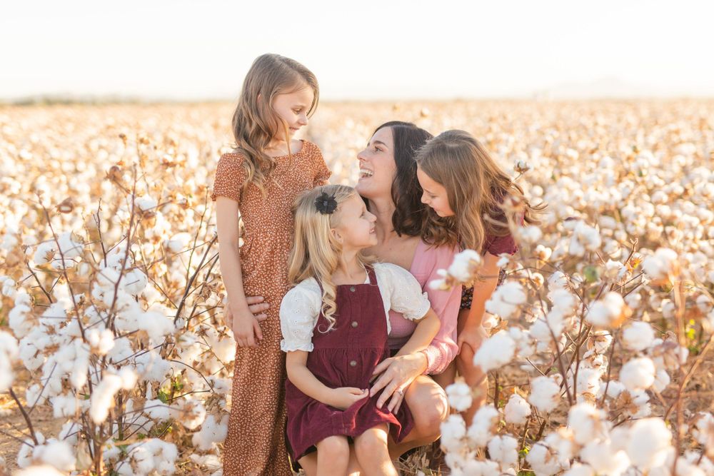 A joyful family moment captured in a cotton field at sunset.