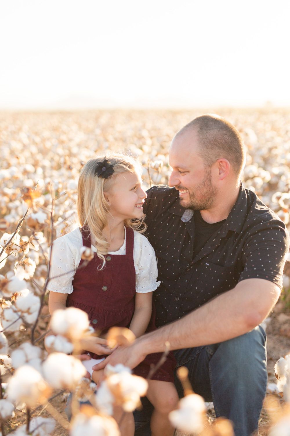 A sweet moment shared between two people among cotton plants at sunset.