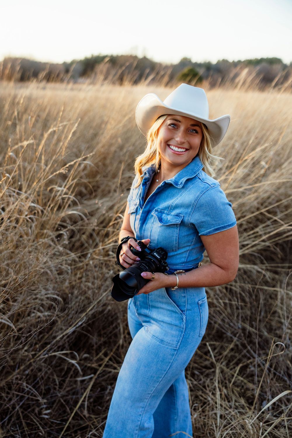 Photographer posing with camera, showcasing their passion for capturing memorable moments and stunning images.